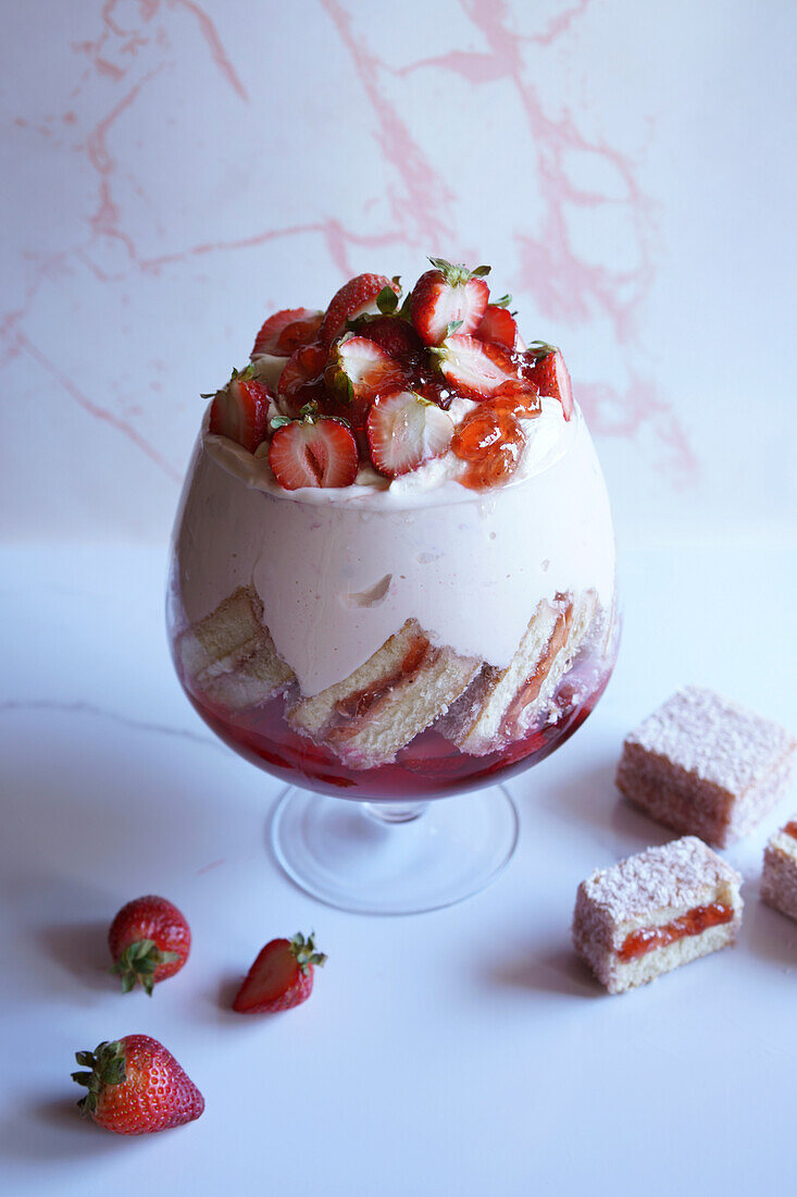 Rosa Lamington-Kuchen und Erdbeer-Joghurt-Gelee-Schicht-Trifle-Dessert.