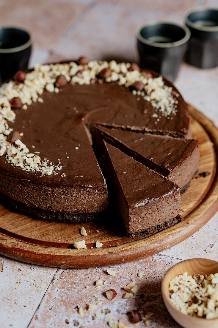 Chocolate cheesecake slices with hazelnuts and coffee on tiles