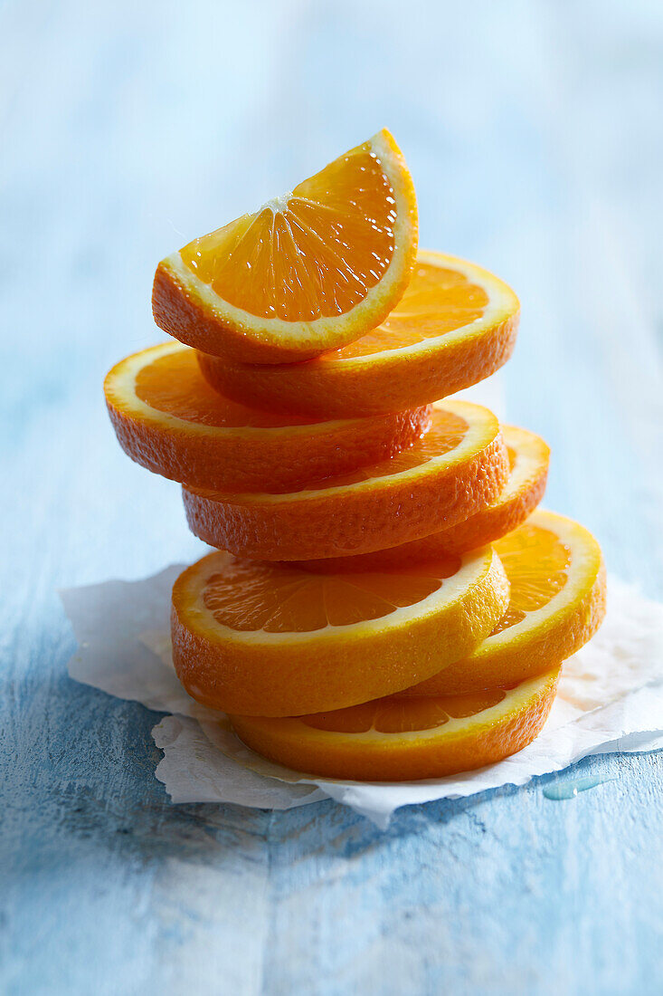 Frisch geschnittene Orangenscheiben, gestapelt auf blauem Hintergrund