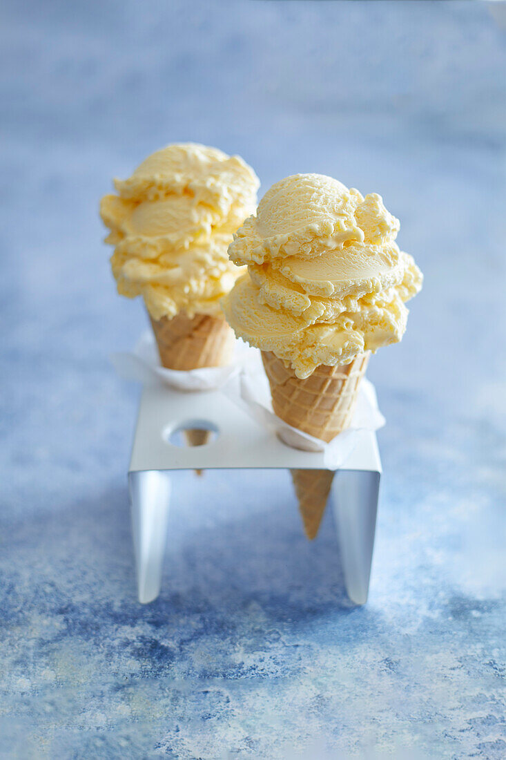 Vanilla ice cream in a cone, in a white ice cream stand, on a blue backround