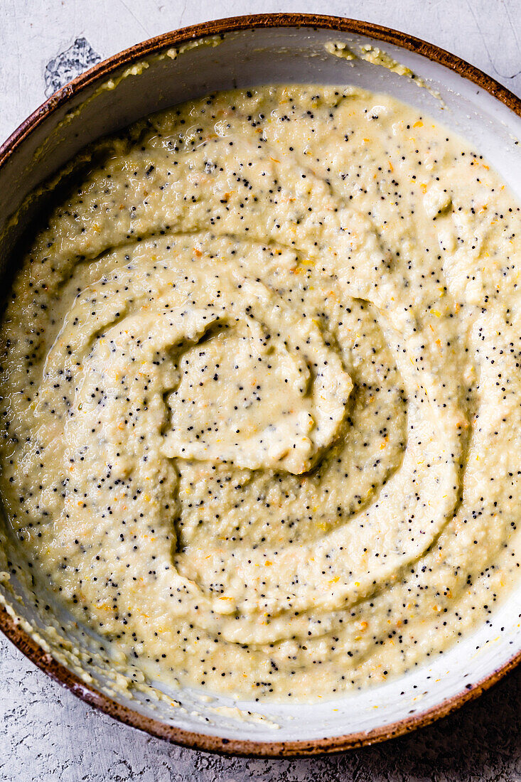 Citrus almond flour poppy seed pancakes in preparation. Hands whisking.