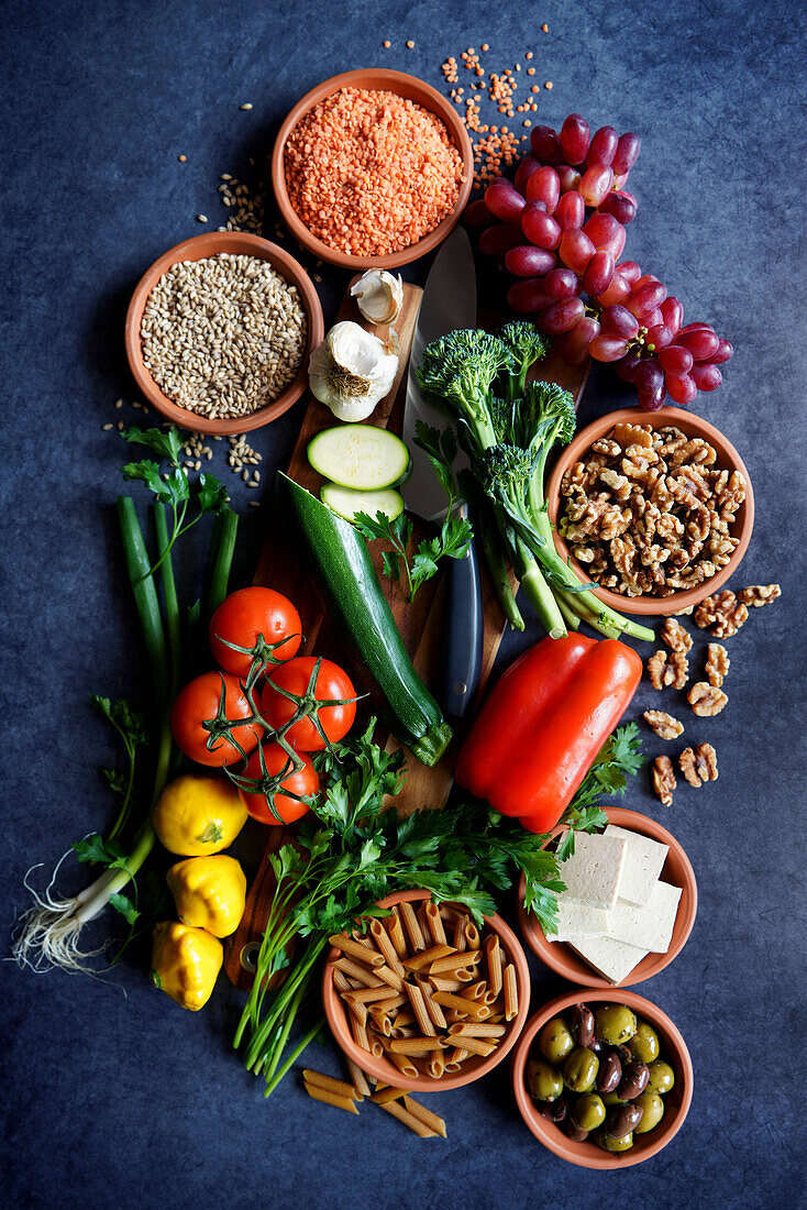 Pflanzliche Vollwertkost mit rohen Zutaten wie Obst, Gemüse, Getreide, Hülsenfrüchte, Tofu und Nüsse.