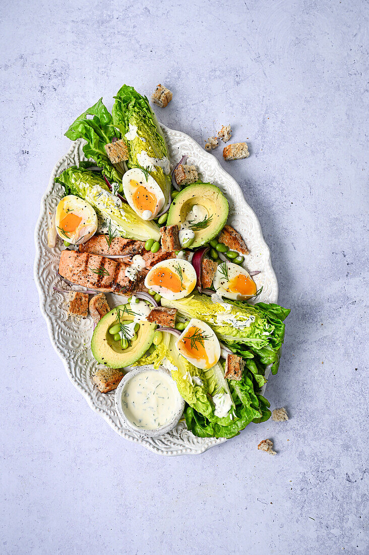 Fresh Salmon Caesar Salad on Light Blue Backdrop