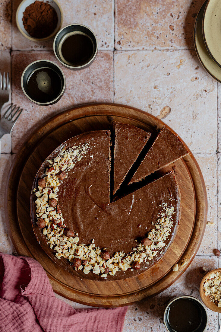 Chocolate cheesecake slices with hazelnuts and coffee on tiles