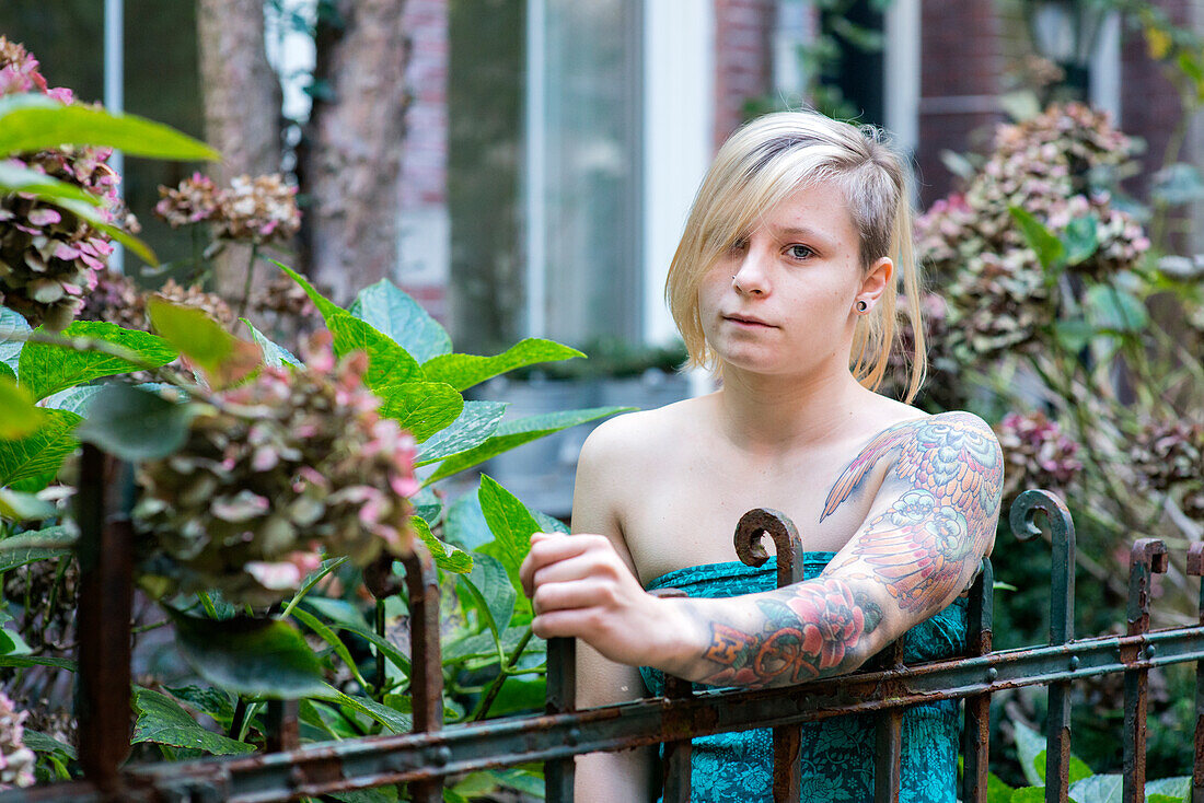 Portrait Young Woman with Tatoos in Residential Garden. Tilburg, Netherlands.