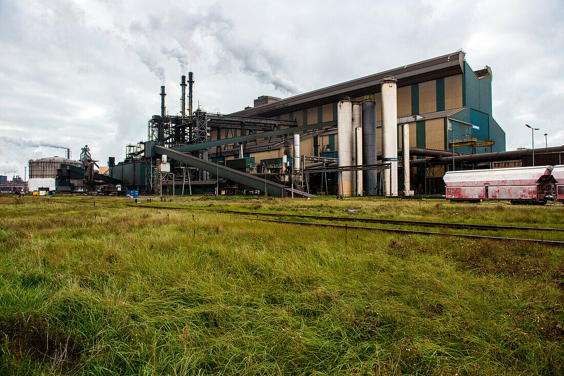 Riesiges, schweres Stahlwerk und Industriegelände, in dem verschiedene Stahlsorten in einer CO2-emittierenden und -absorbierenden Fabrik hergestellt werden. IJmuiden, Niederlande.