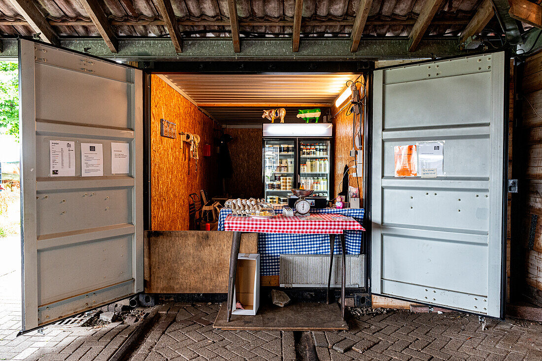 Der Floating Farm Diary Shop verkauft seinen Kunden Molkereiprodukte, die direkt in einem Industriehafen hergestellt werden. Rotterdam, Niederlande.