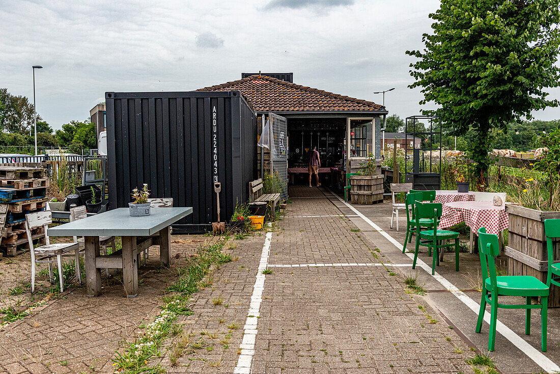 Der Floating Farm Diary Shop verkauft Molkereiprodukte an Kunden, die direkt im Außenbereich eines Industriehafens hergestellt werden. Rotterdam, Niederlande.