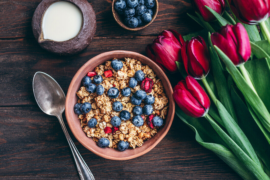 Granola mit Kirschen und Heidelbeeren in einer Keramikschale