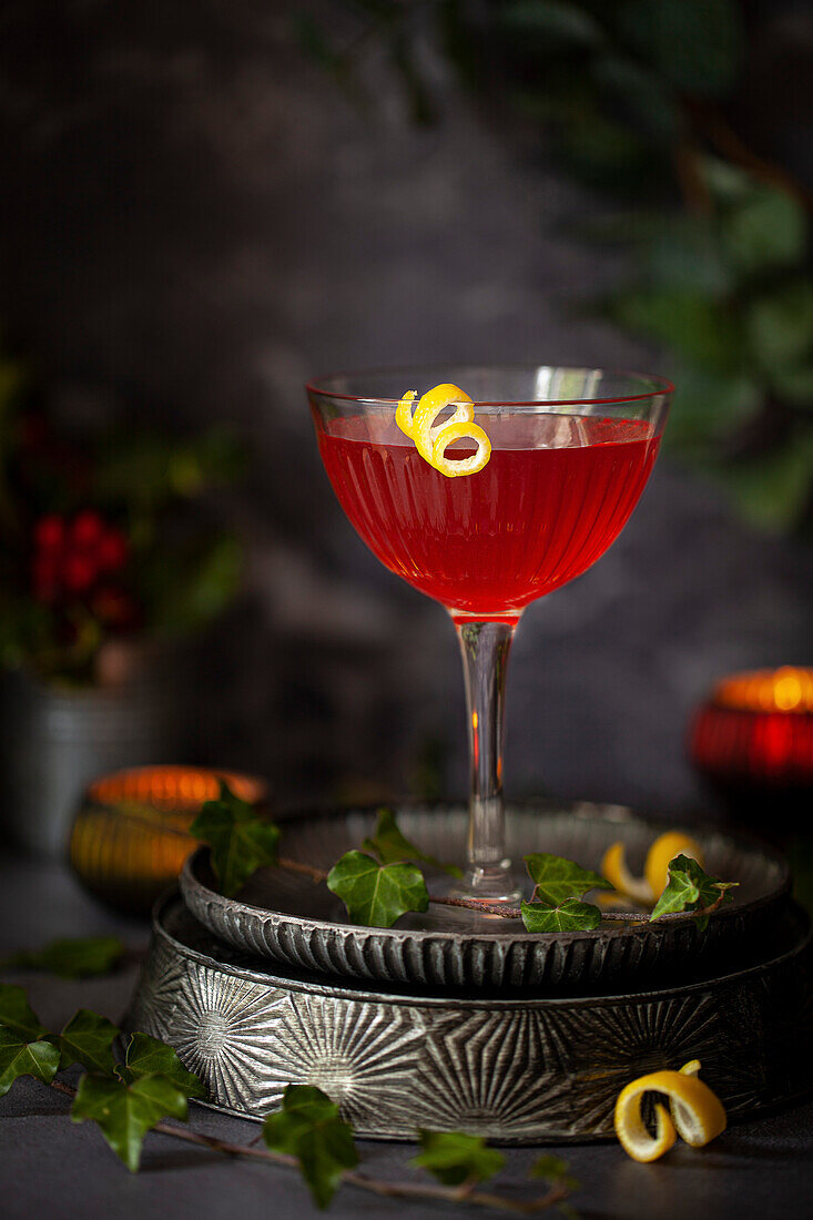 A red cocktail in a coupe cocktail glass