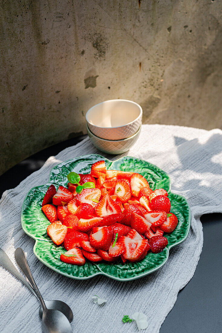 Strawberry with basil, served on a plate outside