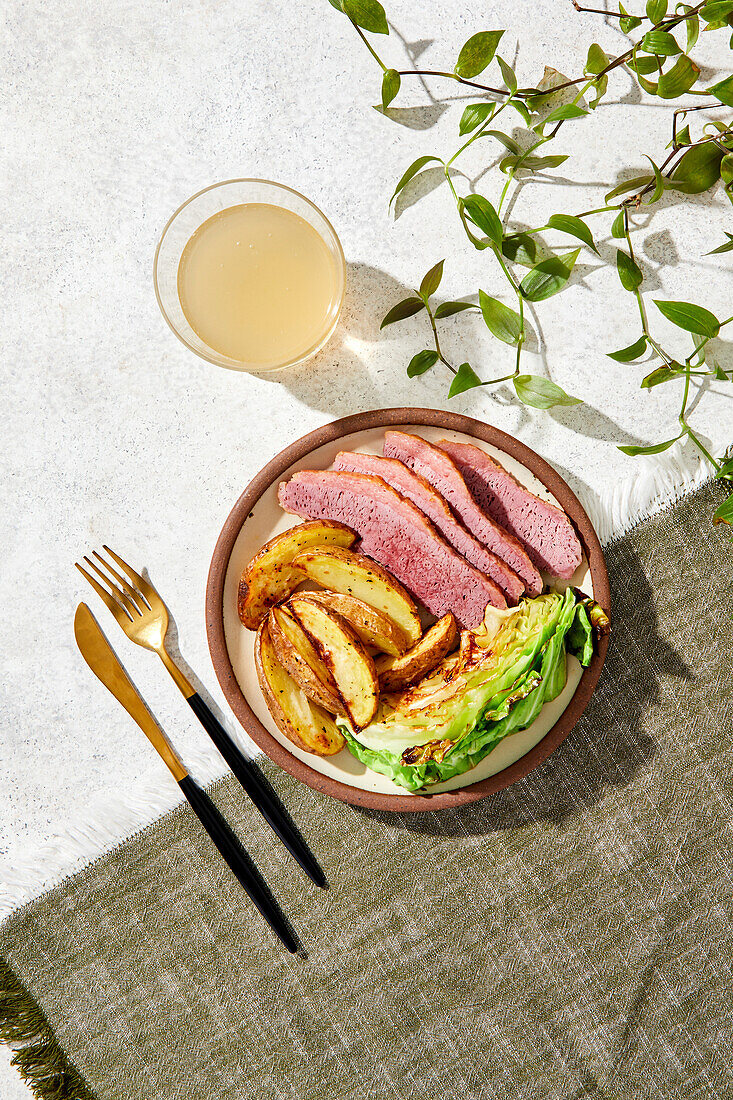 Corned Beef, Roasted Potatoes and Cabbage Meal on a green and white background