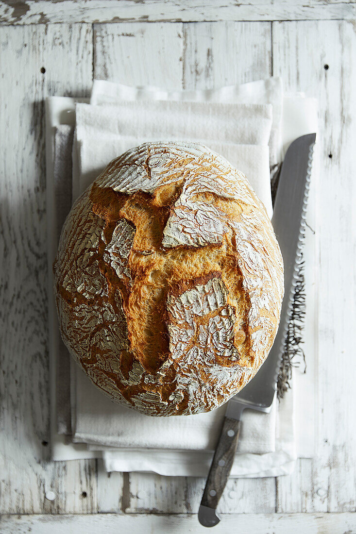 Frisch gebackenes Weizenbrot auf weißem Holzuntergrund