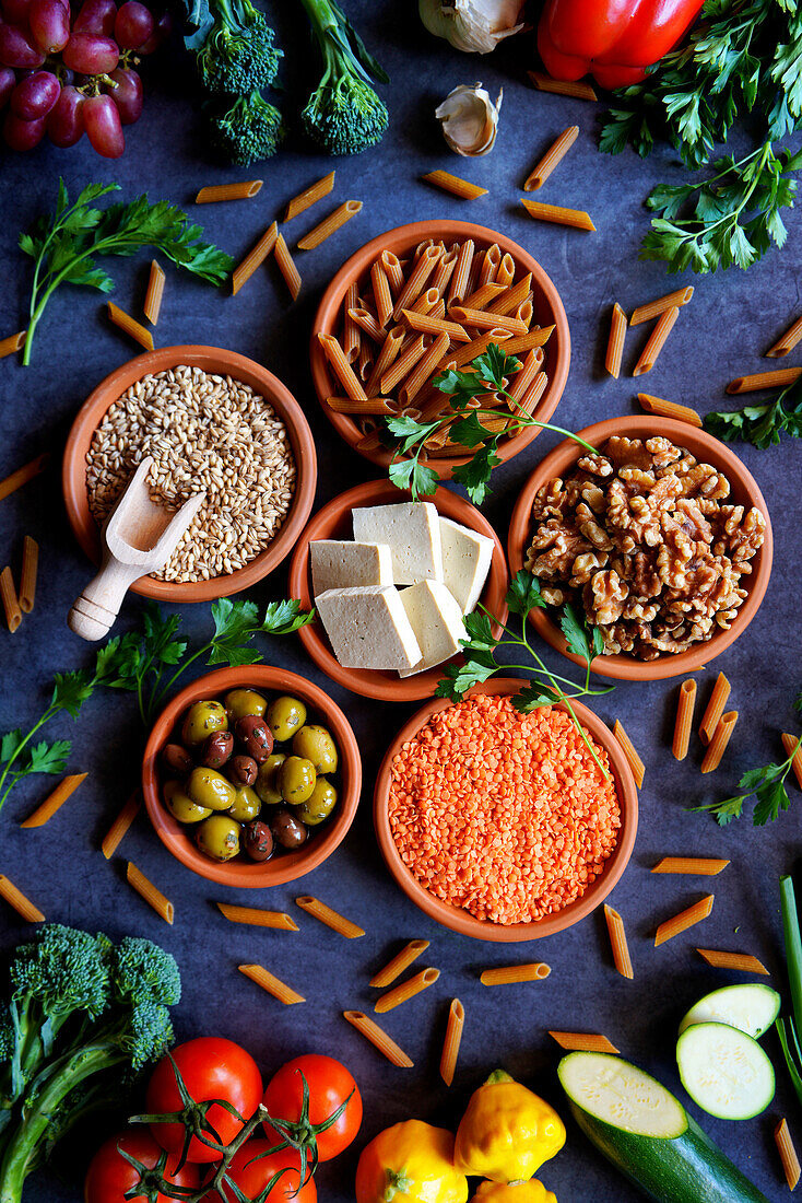 Pflanzliche Vollwertkost mit rohen Zutaten wie Obst, Gemüse, Getreide, Hülsenfrüchte, Tofu und Nüsse.