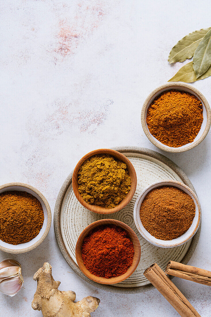 Ground spices in bowls on a neutral background background