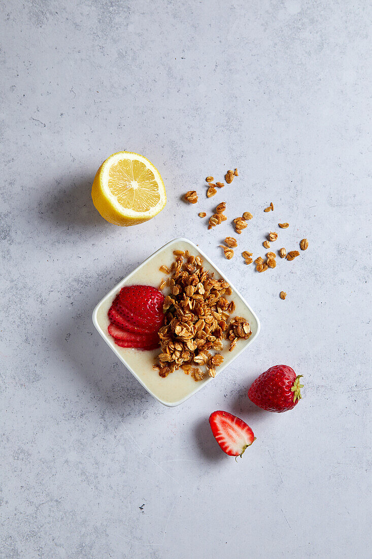 Lemon Strawberry Smoothie Bowl with Granola on a Neutral Background with Soft Shadows