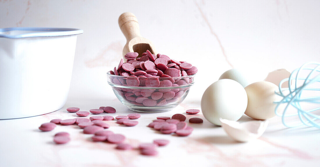 Ruby chocolate made from selected botanical cocoa bean varieties. Cooking concept with callet buttons banner.