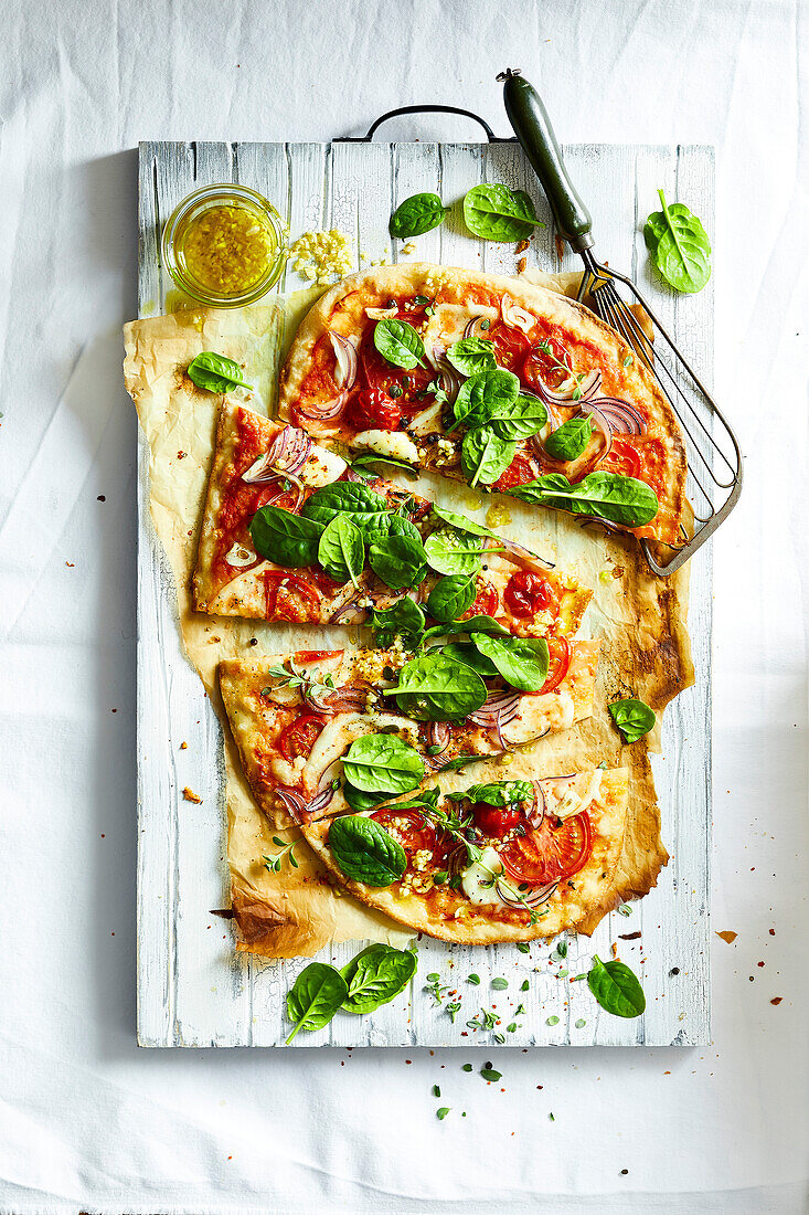 Homemade pizza with fresh spinach and garlic oil