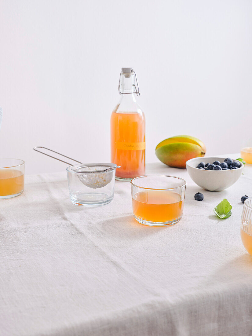 A bottle of homemade fermented kombucha drink with fruit flavour on white background