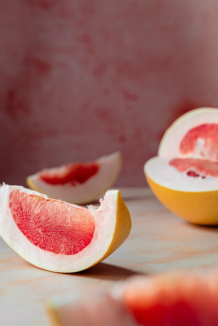 Pink sliced pomelo on pink background