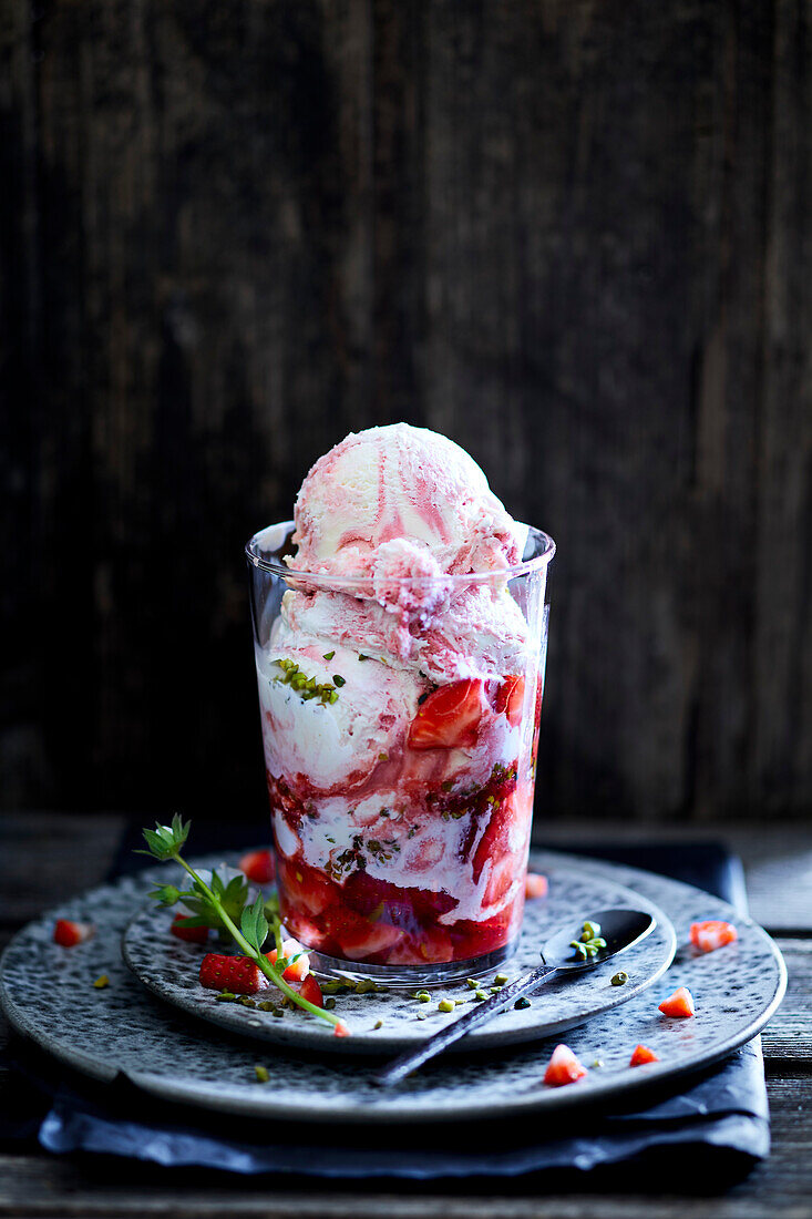 Erdbeereis in einem Glas serviert und mit Erdbeeren dekoriert