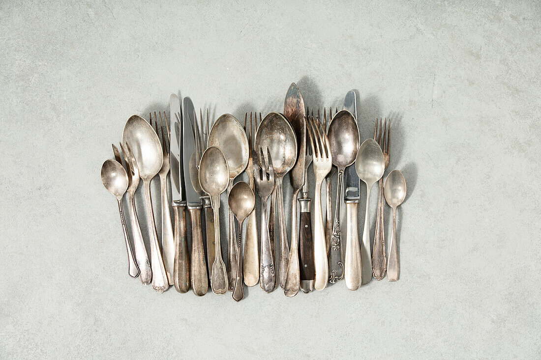 Rustic vintage flatware on a grey stone background Flat lay view from above