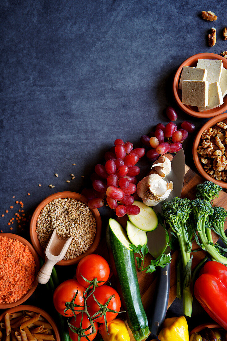 Pflanzliche Vollwertkost mit rohen Zutaten wie Obst, Gemüse, Getreide, Hülsenfrüchte, Tofu und Nüsse.