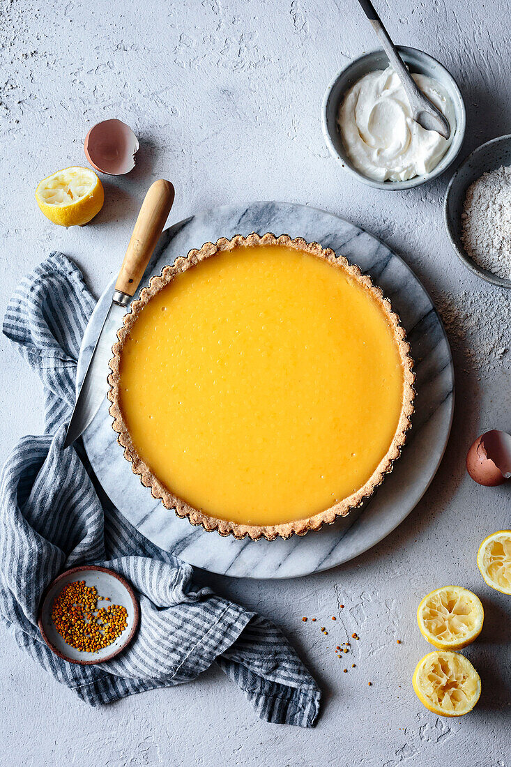 Zitronenkuchen auf einer Marmorplatte mit Zutaten