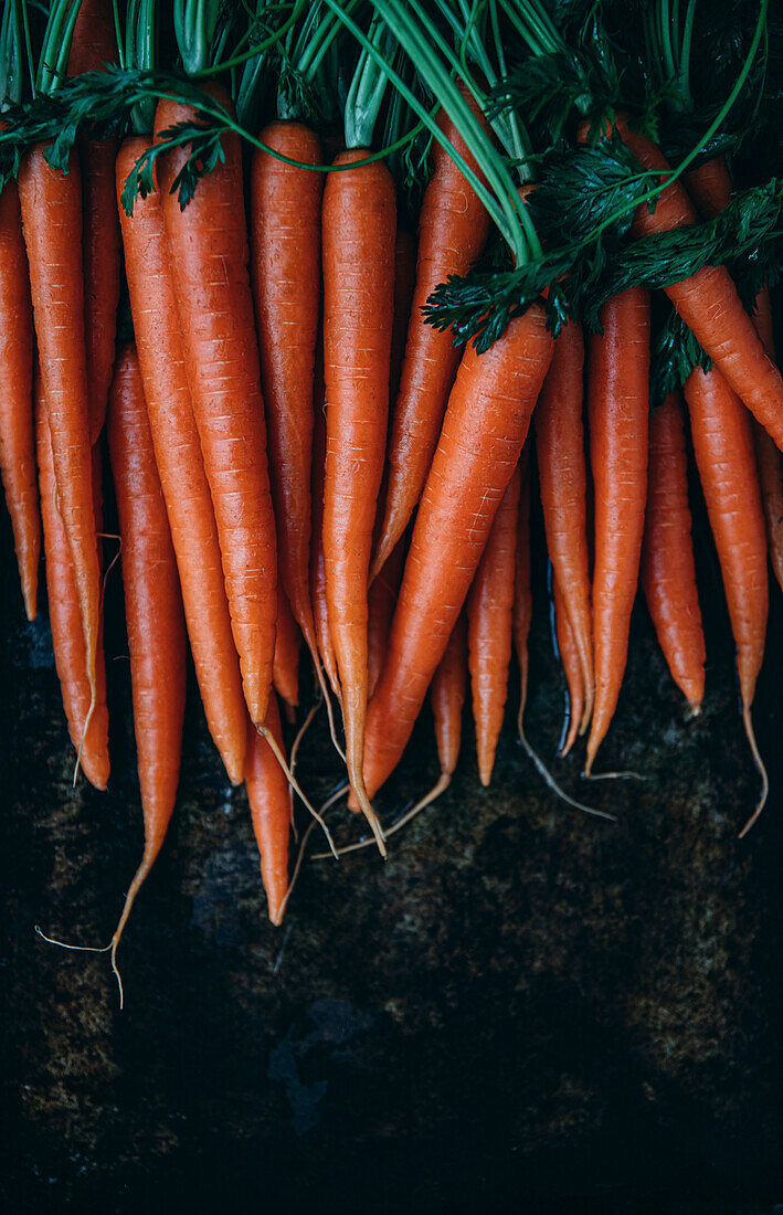 Stacked Carrots against a dark background