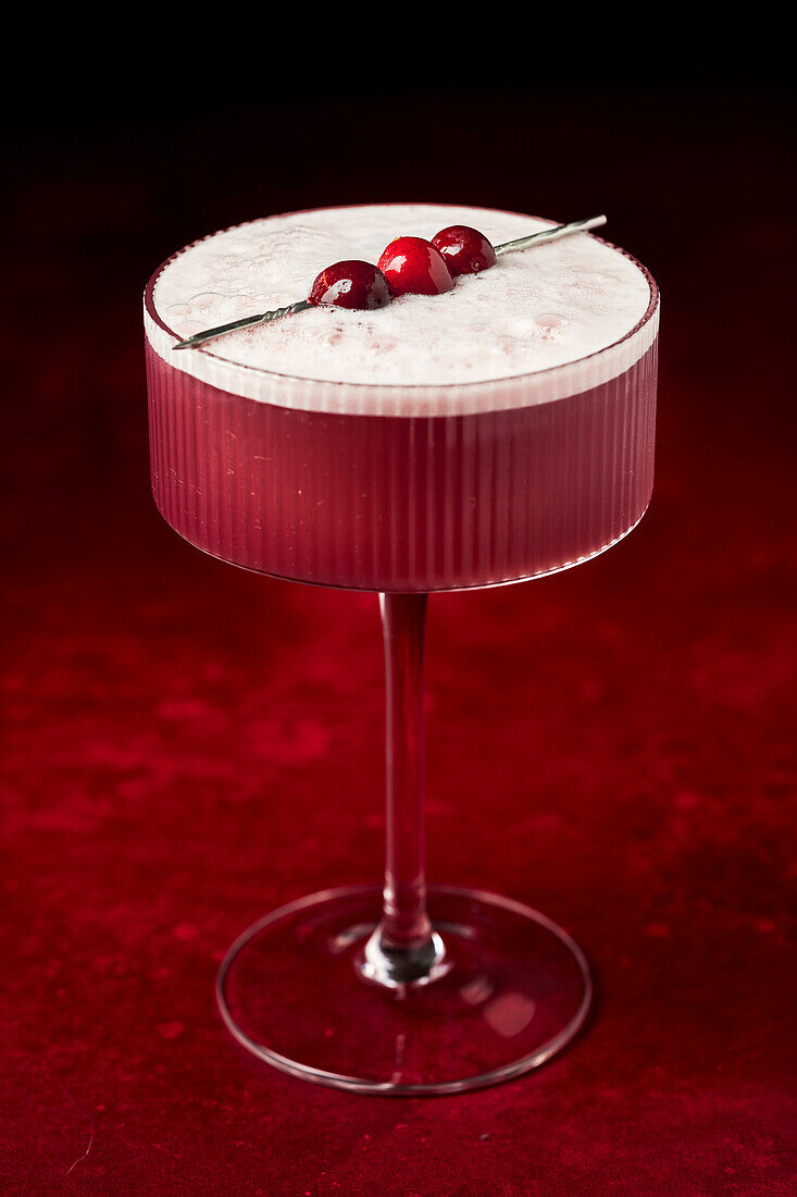 Mulled Wine Sour with Cranberries on Red Surface