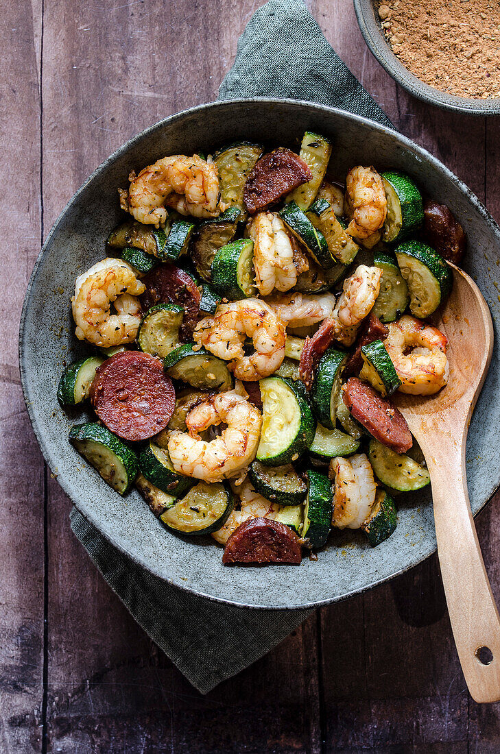 Cajun shrimps with courgettes and spicy salami in a bowl