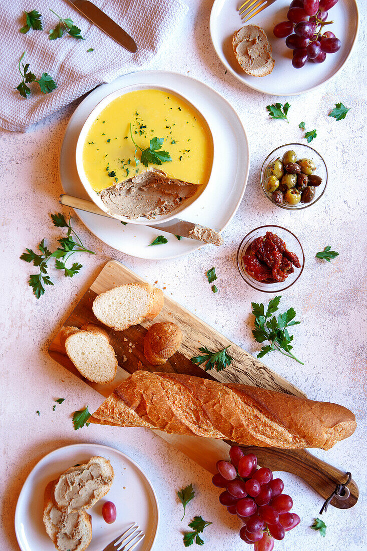 Chicken liver pate served with crusty French baguette bread, olives, and semi-dried tomatoes.