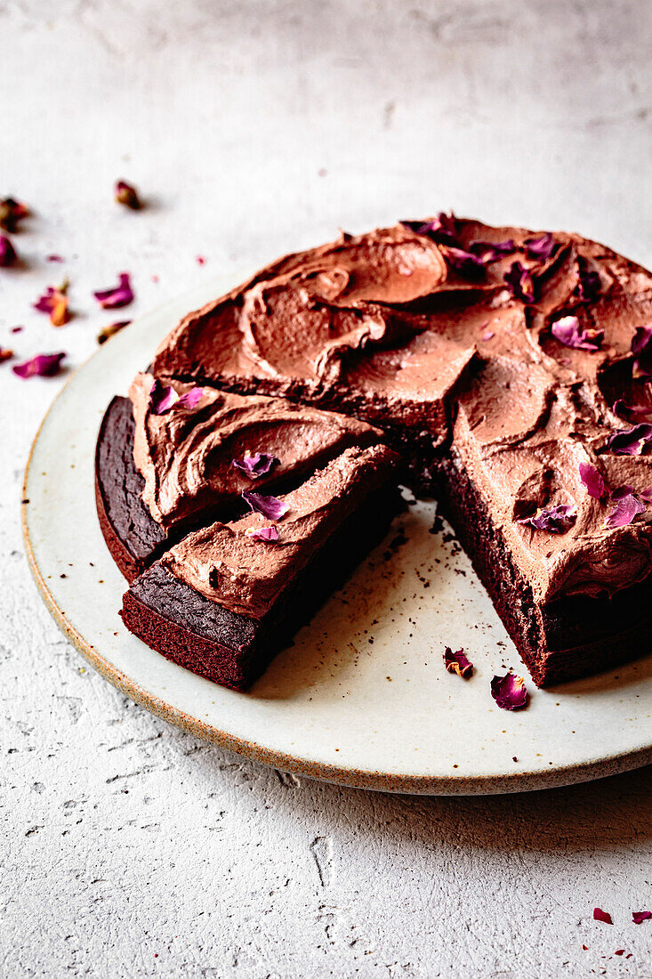 Chocolate cake with chocolate icing and dried rose petals