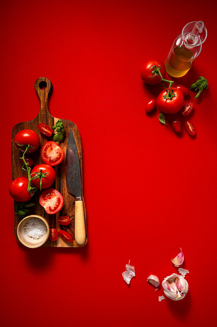 Truss Tomatoes on Chopping Board on Red Backdrop