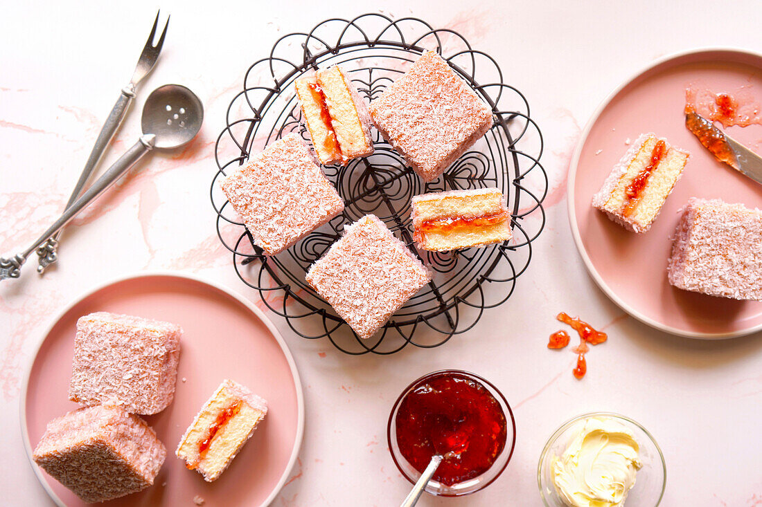 Australian pink lamington. Small square cake with strawberry jam and coconut covering.