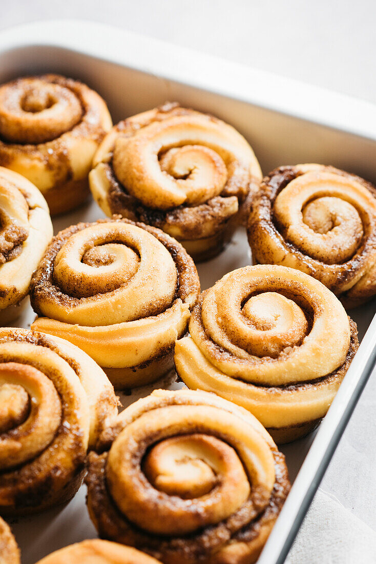 Cinnamon buns baked in a bowl on a light background