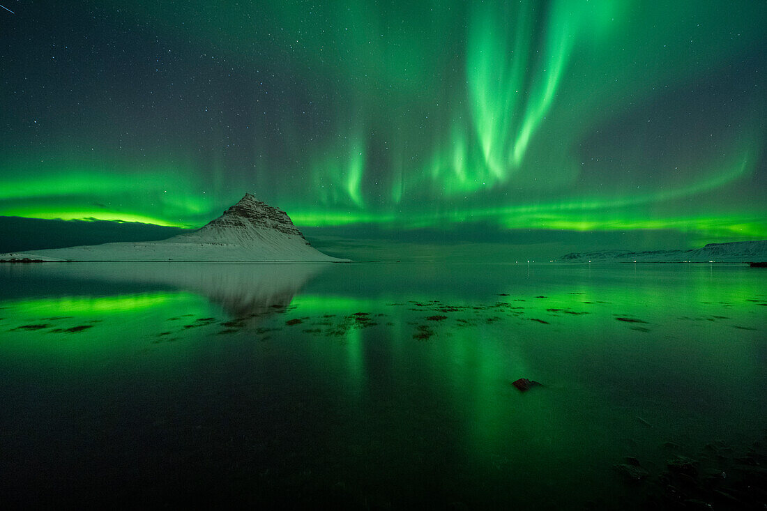 Aurora borealis (Northern Lights) over Kirkjufell Mountain (Wizard's Hat) reflected in ocean, Iceland, Polar Regions