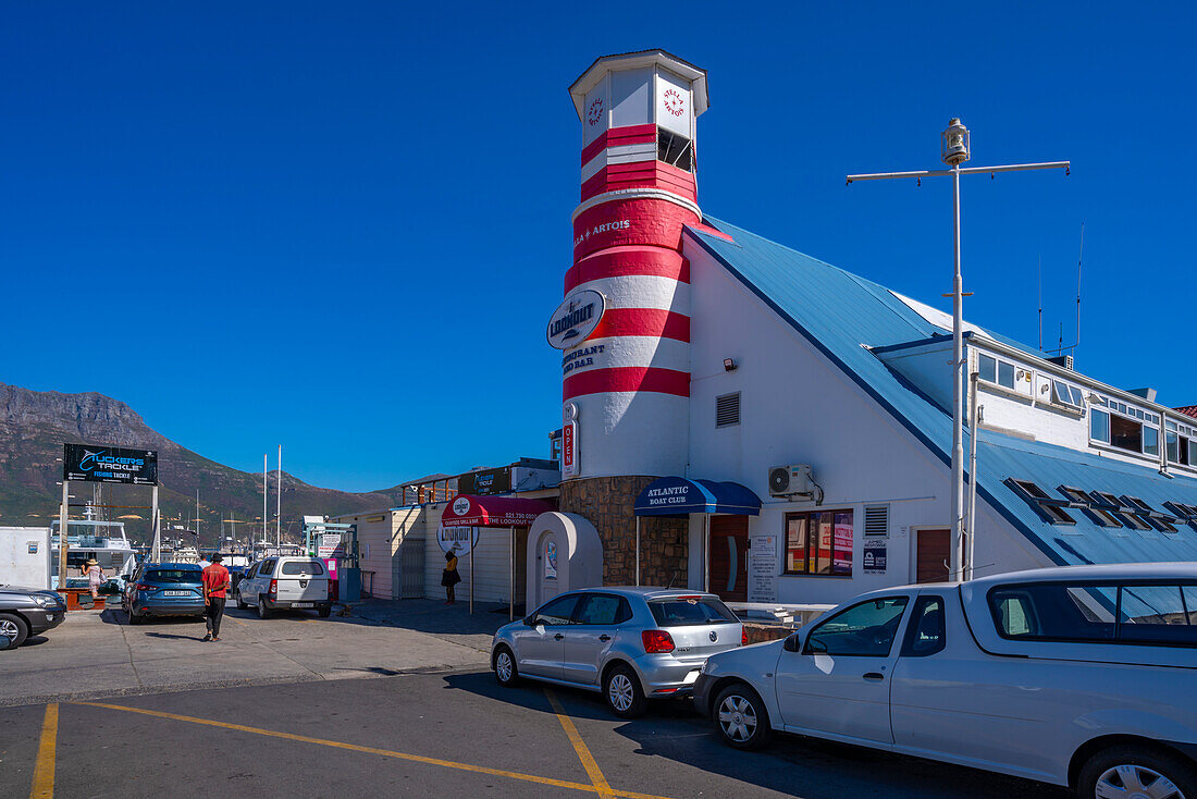 Blick auf bunte Bar und Leuchtturm im Hafen von Hout Bay, Hout Bay, Kapstadt, Westkap, Südafrika, Afrika