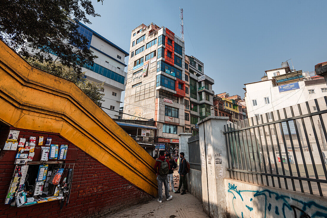 Gelbe Fußgängerbrücke und Zäune, die den Blick auf ein kompliziertes Gebäude an der New Road lenken, Kathmandu, Nepal, Asien