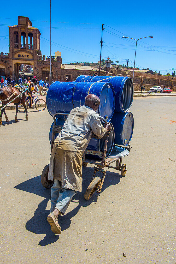 Mann schiebt Fässer zum Medebar-Markt, Asmara, Eritrea, Afrika