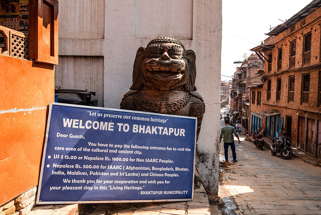 Eingangsschild zur Altstadt von Bhaktapur mit Löwenstatue, die die Gasse bewacht, Bhaktapur, Nepal, Asien