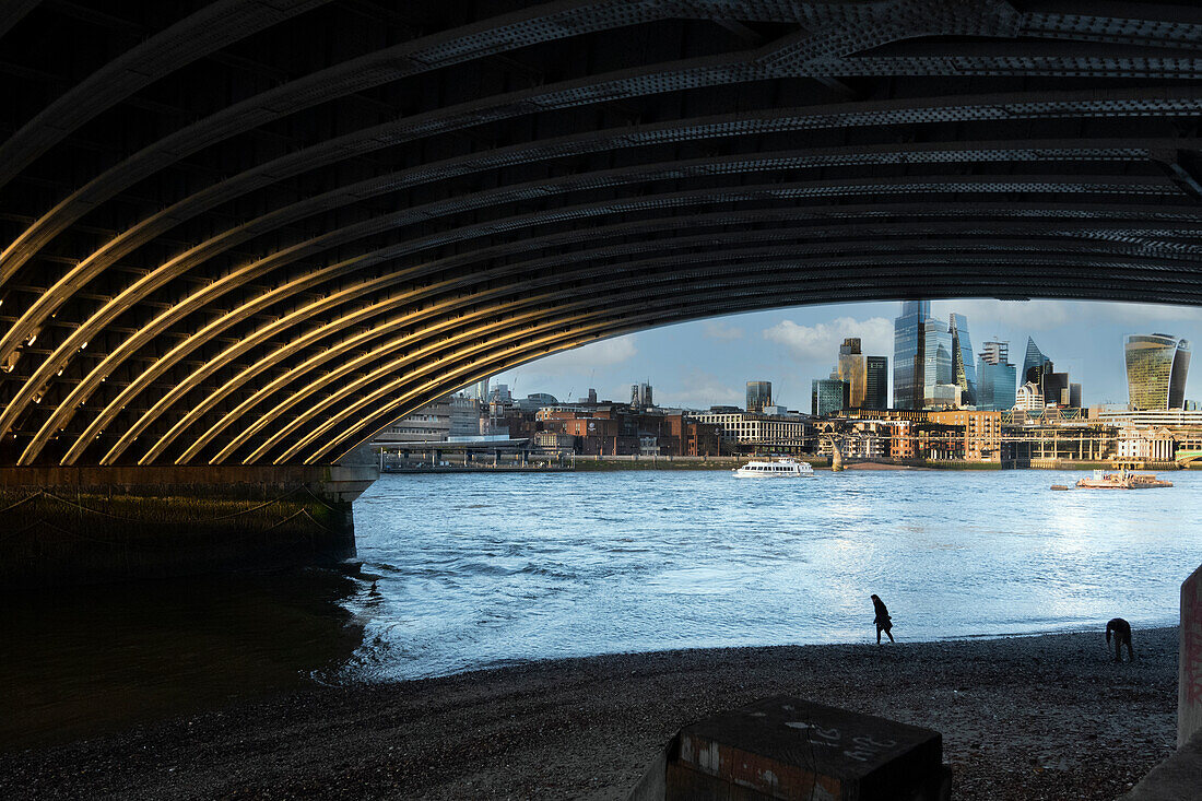 Strandgänger schlendern unter der Blackfriars Bridge am Südufer der Themse, London, England, Vereinigtes Königreich, Europa