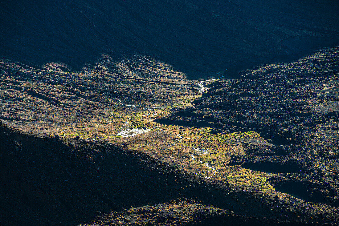 Aerial close up of a sunlit creek surrounded by volcanic ash, Tongariro National Park, UNESCO World Heritage Site, North Island, New Zealand, Pacific