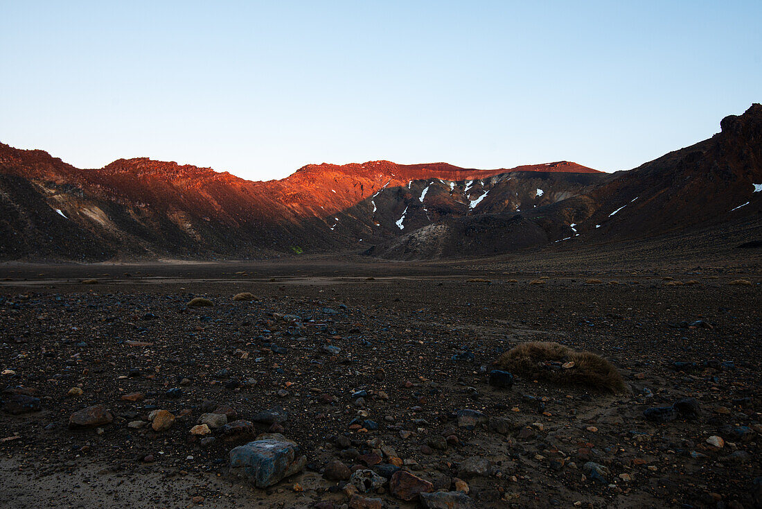 Roter Sonnenaufgang auf dem Kamm des Tongariro-Vulkans und trockene Aschefelder im Vordergrund, Tongariro-Nationalpark, UNESCO-Welterbe, Nordinsel, Neuseeland, Pazifik