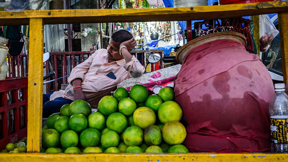 Mann ruht sich hinter seinem Karren mit Limonen aus, Guwahati, Assam, Indien, Asien