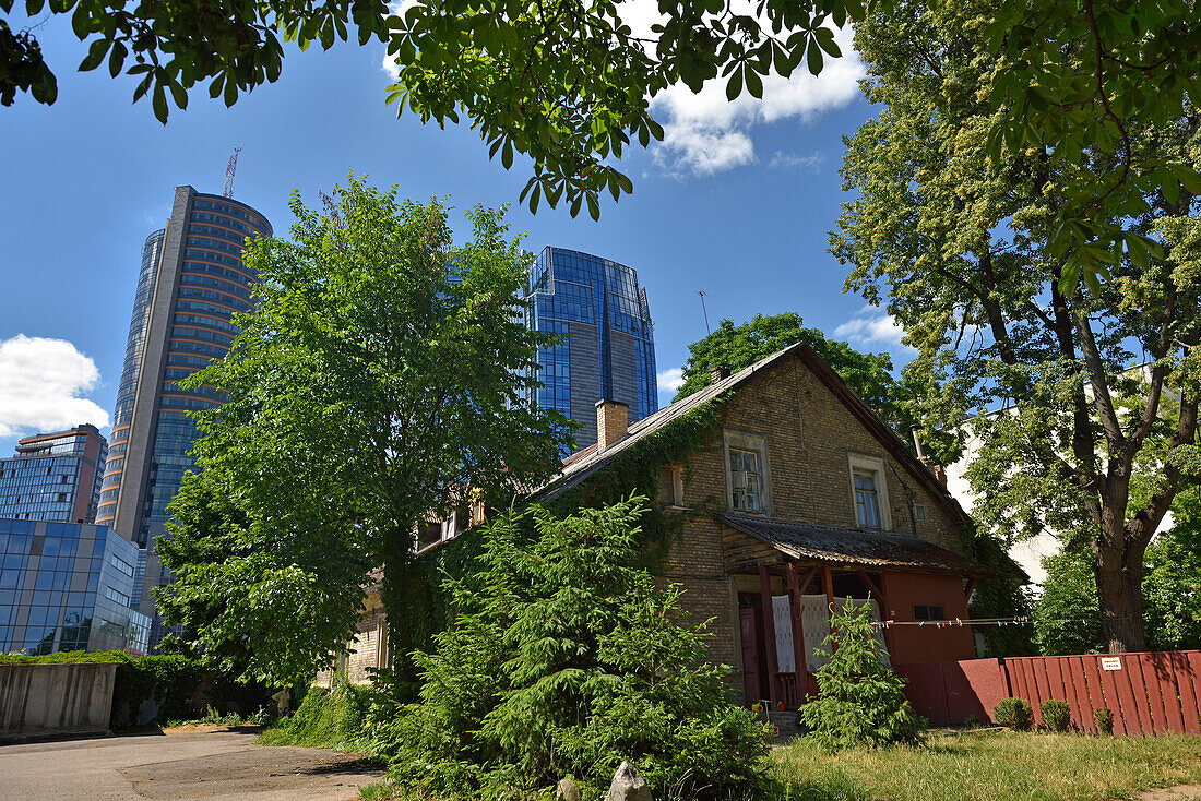 Alte Häuser umgeben von modernen Bürotürmen im Stadtteil Snipiskes, Vilnius, Litauen, Europa