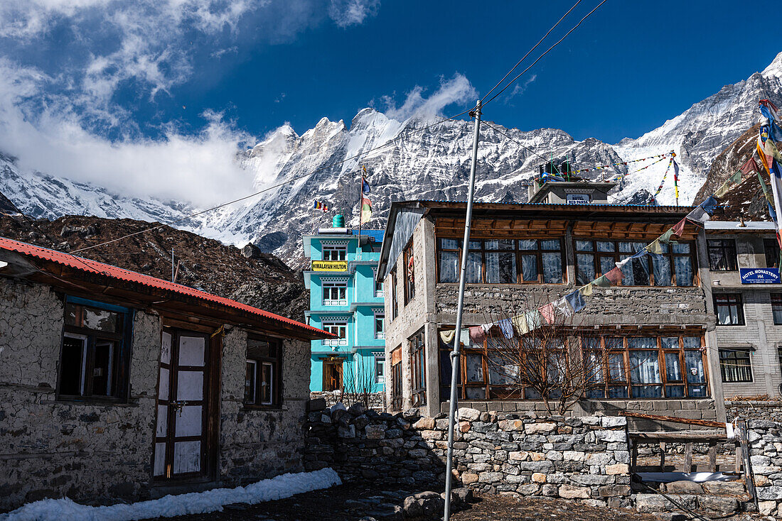 Bunte Häuser bei Kyanjin Gompa mit den hohen Gipfeln des Langtang Lirung im Hintergrund, Lang Tang Valley Trek, Himalaya, Nepal, Asien