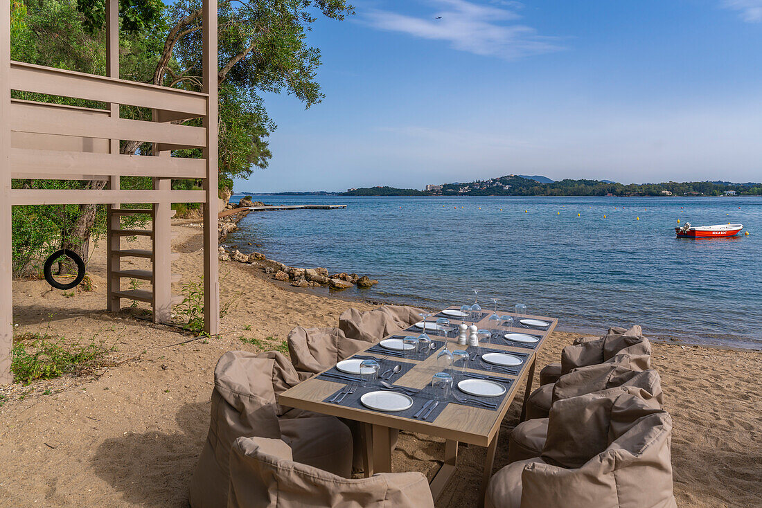 View of alfresco dining table at Dassia Beach and Ionian Sea, Dassia, Corfu, Ionian Sea, Greek Islands, Greece, Europe