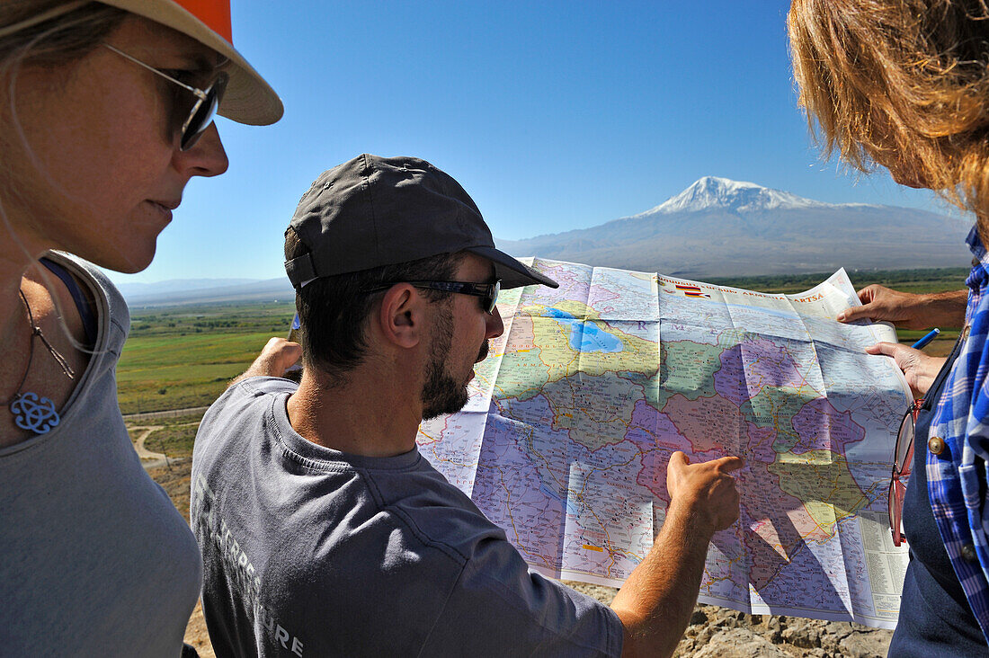 Fremdenführer erklärt einer Touristengruppe die Geografie mit einer Karte, vor der türkischen Grenze und dem Berg Ararat im Kloster Khor Virap, Ararat-Ebene, Artaschat, Armenien, Eurasien