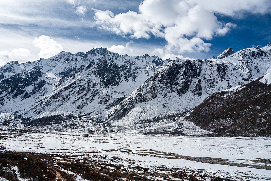 Blick über die schneebedeckte Gletscherebene des winterlichen Hochtals auf dem Langtang-Trek in Kyanjin Gompa, Himalaya, Nepal, Asien